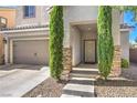 Inviting entryway with stone accents, desert landscaping, and a covered front door with a storm door at 9113 Sea Mink Ave, Las Vegas, NV 89149