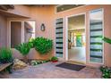 Inviting front courtyard with tile flooring and tropical plants provides a welcoming entrance into the home at 9233 Canyon Mesa Dr, Las Vegas, NV 89144