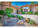 Landscaped front yard with desert rock garden and lush tropical foliage enhances the curb appeal of this lovely home at 9233 Canyon Mesa Dr, Las Vegas, NV 89144