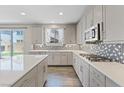 Modern kitchen featuring stainless steel appliances, white countertops and patterned backsplash at 10058 Matter Overlook Dr, Las Vegas, NV 89178