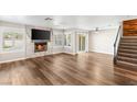 Sun-lit living room featuring wood flooring, a fireplace, and access to the backyard patio at 1125 Lumina Ct, Las Vegas, NV 89117