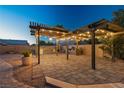 Outdoor kitchen and patio area featuring built-in grill, pergola with lighting, and paver flooring at 231 Bristle Cone, Pahrump, NV 89048