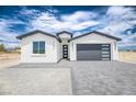 Beautiful modern home with gray accents, desert landscaping, and a modern garage door at 2461 S Blagg Rd, Pahrump, NV 89048