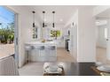 White kitchen with breakfast bar, modern pendant lights, and stainless steel appliances and light colored floor at 2724 Natalie Ave, Las Vegas, NV 89121