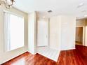 Charming foyer featuring hardwood floors, white tiled floors, a white entry door, and a brightly lit room at 3542 Harbor Tides St, Las Vegas, NV 89147
