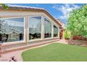 The backyard has a well-kept lawn and sizable windows that let in plenty of natural light at 3741 Via Gaetano, Henderson, NV 89052