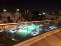 Illuminated community pool at night, surrounded by palm trees and modern residential buildings at 4575 Dean Martin Dr # 303, Las Vegas, NV 89103