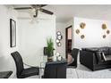 Dining area featuring a glass-top table with black chairs and a black leather sofa in the background at 4955 Jeffreys St # 605, Las Vegas, NV 89119