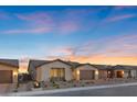 This single-story home boasts desert landscaping, a neutral color scheme, and a spacious two-car garage at 5081 Notting Hill Ave, Las Vegas, NV 89139