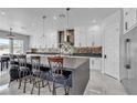 Open-concept kitchen with white cabinets, stainless steel appliances, and a large island with bar seating at 6235 N Fort Apache Rd, Las Vegas, NV 89149