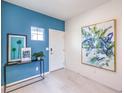 Modern entryway with stylish console table, artwork, blue accent wall, and tile floors at 7437 Cooper Cove Dr # 30, North Las Vegas, NV 89084