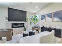 Bright living room with modern fireplace, wood floors, and comfortable seating arrangement at 7772 Buckwood Ct, Las Vegas, NV 89149