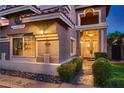 Elegant home entrance features a beautifully illuminated door and manicured landscaping at 9583 Gainey Ranch Ave, Las Vegas, NV 89147