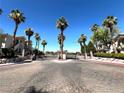 Elegant gated entrance with palm trees offers security and a welcoming first impression of the community at 1521 Ruby Cliffs Ln # 104, Las Vegas, NV 89144
