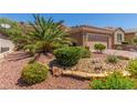 Inviting home features a well-maintained yard with desert landscaping and stone accents at 2398 Jada Dr, Henderson, NV 89044