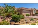Inviting home features a well-maintained yard with desert landscaping and stone accents at 2398 Jada Dr, Henderson, NV 89044