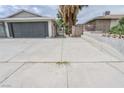 Long concrete driveway leading to a two-car garage, with a palm tree nearby at 4269 Roanridge Ave, Las Vegas, NV 89120