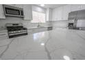 Modern kitchen features white cabinets, stainless steel appliances, and a marble countertop island at 4269 Roanridge Ave, Las Vegas, NV 89120
