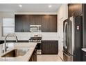 Close-up showcasing a kitchen island, stainless steel appliances, and dark wood cabinets at 532 Monarch Ridge Ct, North Las Vegas, NV 89084