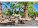 Stone waterfall feature in the backyard with desert landscaping at 536 Pima Canyon Ct, Las Vegas, NV 89144