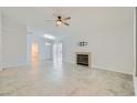 Bright, open living room with neutral tile flooring, ceiling fan, and fireplace at 5425 Comchec Way # 103, Las Vegas, NV 89108