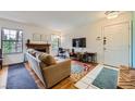 Cozy living room with a brick fireplace, hardwood floors, and ample natural light from windows at 5576 W Rochelle Ave # 27C, Las Vegas, NV 89103