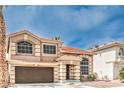 Charming home exterior featuring a two-car garage, red tile roof, an arched window and well-maintained landscaping at 8737 Autumn Valley Ave, Las Vegas, NV 89129