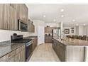 A spacious kitchen features granite countertops, stainless steel appliances and tiled flooring at 8937 Pelican Point St, Las Vegas, NV 89178