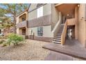Two-story condominium exterior showcasing outdoor staircase access and landscaping at 2200 S Fort Apache Rd # 1101, Las Vegas, NV 89117