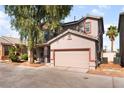 Two-story home featuring a two-car garage with a well-kept front yard at 2400 Dutchmans Pipe Ct, Las Vegas, NV 89106