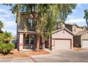Inviting two-story home with a two-car garage and mature landscaping at 2400 Dutchmans Pipe Ct, Las Vegas, NV 89106