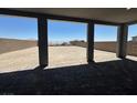 A covered patio overlooks a spacious backyard with a sturdy block fence and beautiful desert landscaping at 560 Preston Oak Pl, Las Vegas, NV 89138