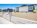 The house has a neatly kept front yard with desert-style landscaping and a decorative white brick fence at 6236 Foothill Blvd, Las Vegas, NV 89118