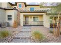 Charming home exterior with desert landscaping, a stone walkway, and a cozy front porch at 675 Omaggio Pl, Henderson, NV 89011