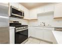 Modern kitchen showcasing white cabinets, stainless steel appliances, and light countertops at 675 Omaggio Pl, Henderson, NV 89011