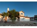 Inviting two-story home featuring mature landscaping, a well-maintained lawn, and an attached two-car garage at 860 Bergamont Dr, Henderson, NV 89002