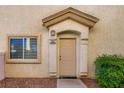 Close up of the front door and entryway with a small window and landscape at 8842 Duncan Barrel Ave # 103, Las Vegas, NV 89178