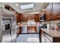 Well-lit kitchen featuring stainless steel appliances, dark wood cabinets and a light-colored tile floor at 1949 King Hill St, Las Vegas, NV 89106