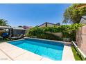 Backyard pool with blue tile accents and lush landscaping perfect for relaxing and entertaining under the sun at 1949 King Hill St, Las Vegas, NV 89106