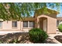 Exterior view of cozy home with an arched entry, desert landscaping, and lush green shrubbery at 2141 Hussium Hills St # 108, Las Vegas, NV 89108