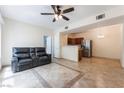 Spacious open floor plan with tile flooring, ceiling fan, and kitchen with stainless steel appliances at 2141 Hussium Hills St # 108, Las Vegas, NV 89108