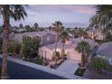 Beautiful aerial view of a single-story house with a tile roof surrounded by desert landscaping and palm trees at 2824 Evening Rock St, Las Vegas, NV 89135