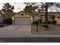 Inviting single-story home with a two-car garage, decorative details, and well-maintained front yard at 4908 Winterset Dr, Las Vegas, NV 89130
