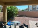 View of backyard with patio, brick retaining wall, decorative rock, and lush landscaping at 7064 Coventry Glenn Rd, Las Vegas, NV 89148