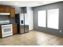 Bright kitchen featuring modern stainless steel refrigerator and tile flooring at 8089 Windmill Villa St, Las Vegas, NV 89139