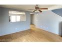 An empty living room featuring wood floors, blue walls, and a ceiling fan at 8089 Windmill Villa St, Las Vegas, NV 89139