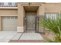 A cozy two-story home's front entrance features a gated courtyard and three-car garage at 8929 Monte Oro Dr, Las Vegas, NV 89131