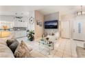 An open concept living room showcasing tile floors, modern decor, and stainless kitchen appliances at 2093 Seahurst Dr, Las Vegas, NV 89142