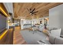 Spacious open-concept living area with wood ceiling, sleek furnishings and flowing access to other living spaces at 2548 Faiss Dr, Las Vegas, NV 89134