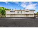 Exterior view of two-story building with private garages and desert landscaping at 2627 S Durango Dr # 201, Las Vegas, NV 89117